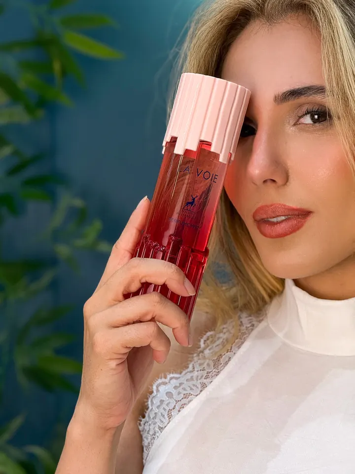 Mulher segurando o Perfume Mist La Voie, da Maison Alhambra, junto ao rosto